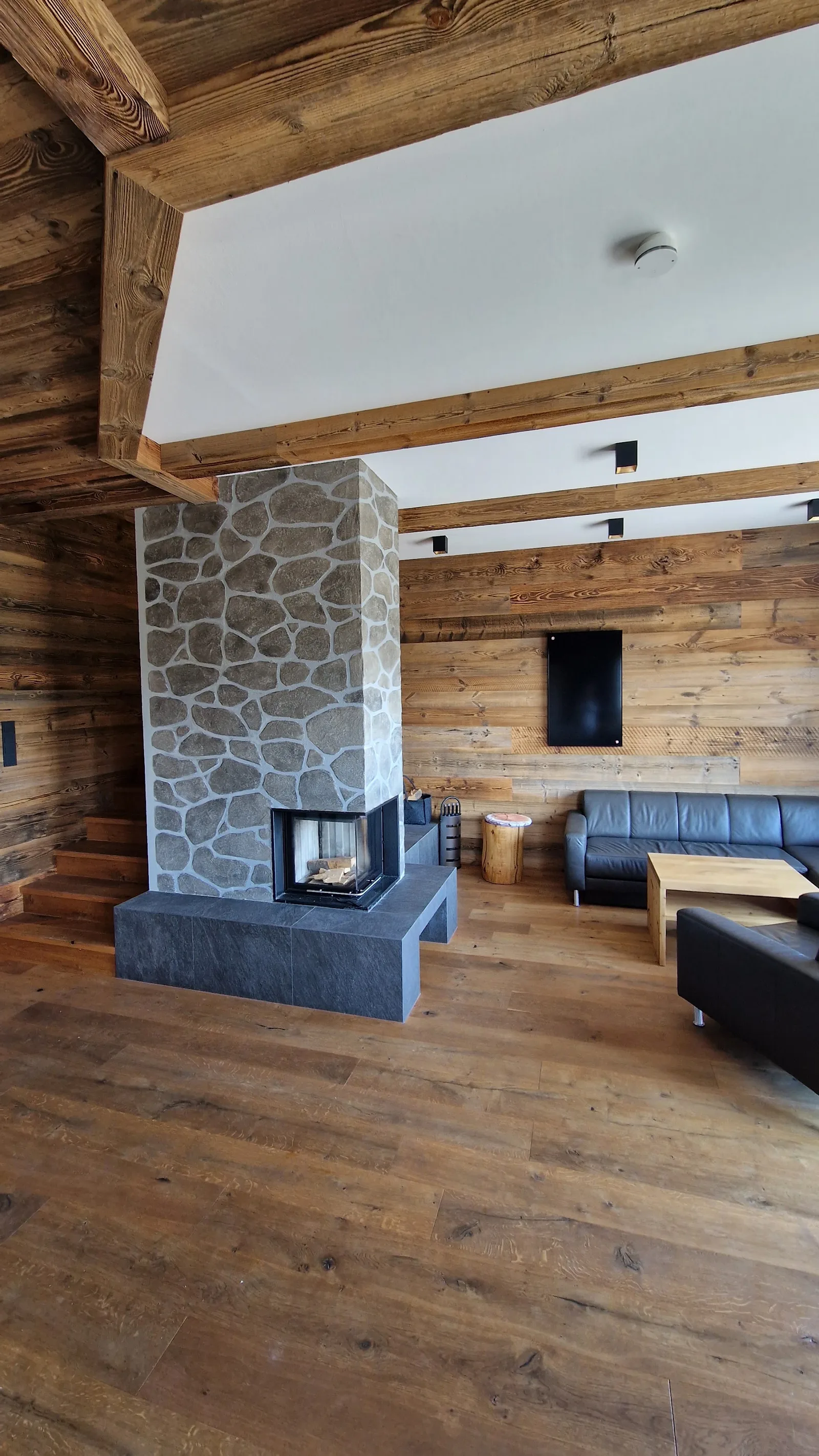 Wohnraum mit Holz, Naturstein und Kamin