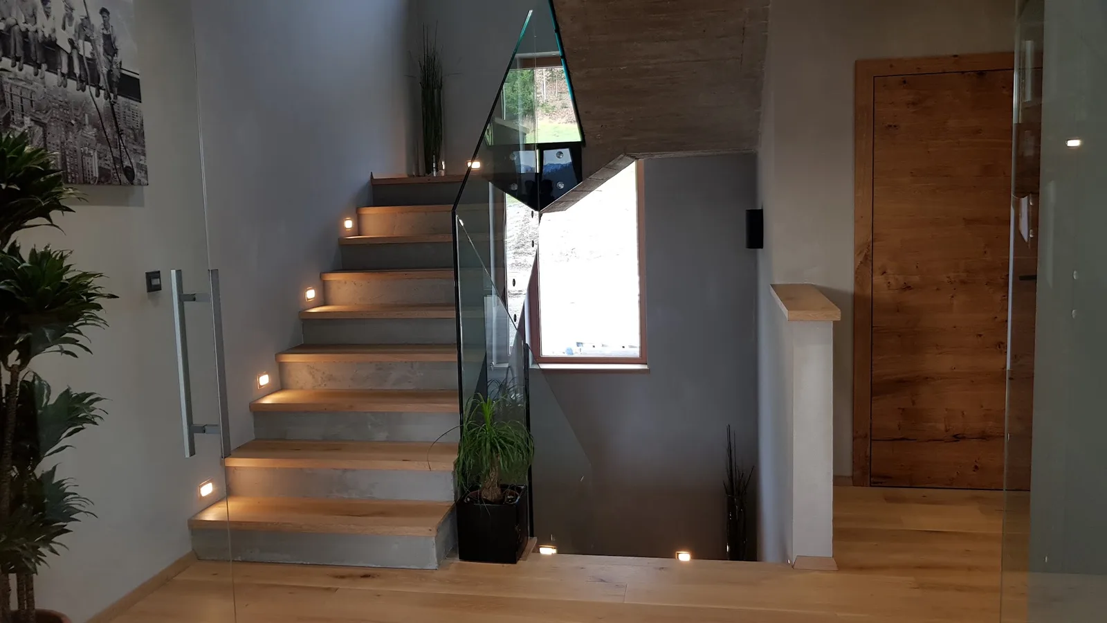 Treppenraum mit Wandgestaltung und Glasgeländer
